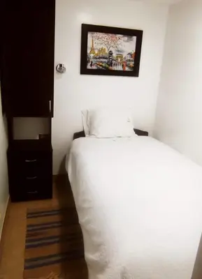 a bedroom with a white bed and a picture on the wall at ANDAHUAYLAS CENTRO in Andahuaylas