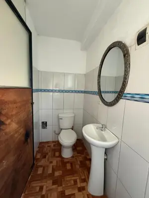 a bathroom with a toilet and a sink and a mirror at Vertigo Climbing Hostel in Urubamba