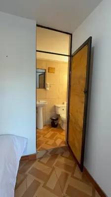 an open door to a bathroom with a toilet at Vertigo Climbing Hostel in Urubamba
