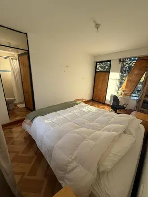 a bedroom with a large white bed in it at Vertigo Climbing Hostel in Urubamba