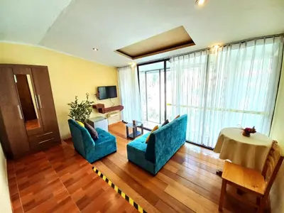a living room with two blue chairs and a table at Hotel Humantay lodge Ollantaytambo in Ollantaytambo