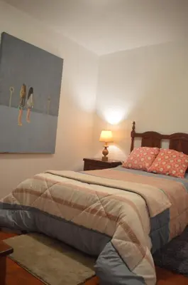 a bedroom with a bed with a painting on the wall at ROOM Lima House centro in Lima