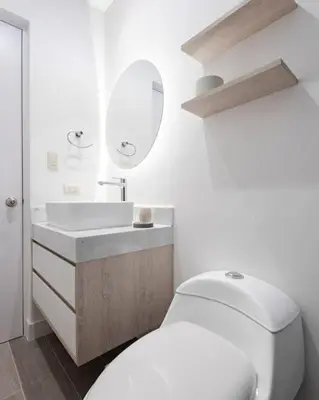 a white bathroom with a toilet and a sink at Stunning Modern 1BD Apartment in Barranco in Lima