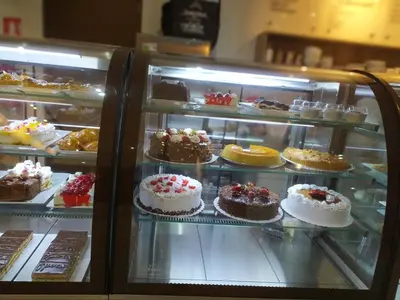a display case filled with lots of cakes and pastries at apartamento de estreno con balcón frente al mar. in Lima