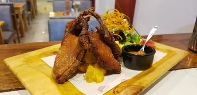a plate of fried food with a salad and dipping sauce at TAYWA HOTEL in Machu Picchu
