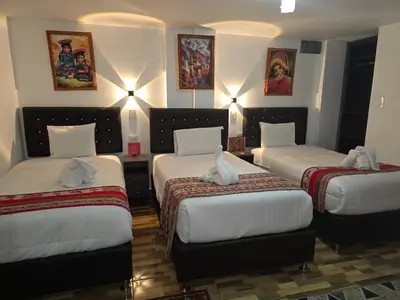 a hotel room with three beds with stuffed animals on them at TAYWA HOTEL in Machu Picchu