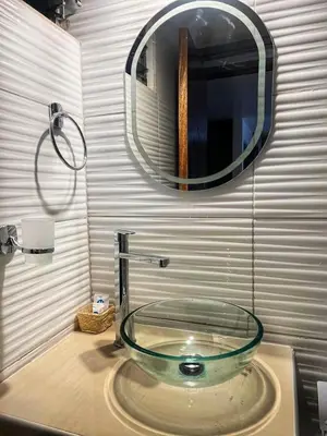 a glass sink in a bathroom with a mirror at TAYWA HOTEL in Machu Picchu