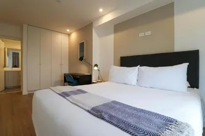 a bedroom with a white bed with a blue blanket on it at Sky Balta in Miraflores by Wynwood House in Lima