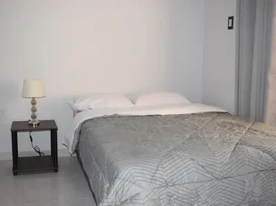 a bedroom with a bed and a night stand with a lamp at El Valle - Lunahuaná in Lunahuaná