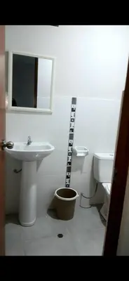 a white bathroom with a sink and a toilet at El Valle - Lunahuaná in Lunahuaná