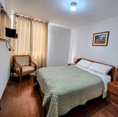 a hotel room with a bed and a chair at Casita Cultura in Lima