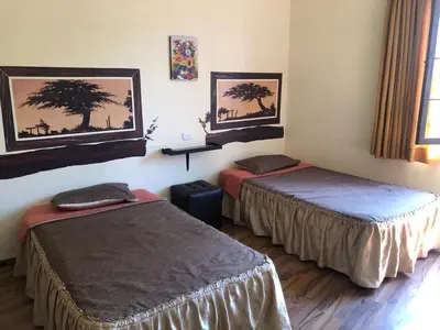 a hotel room with two beds and a window at Hostal Huacachina Sunset in Ica