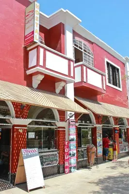a red building with two balconies on a street at Hostal Huacachina Sunset in Ica