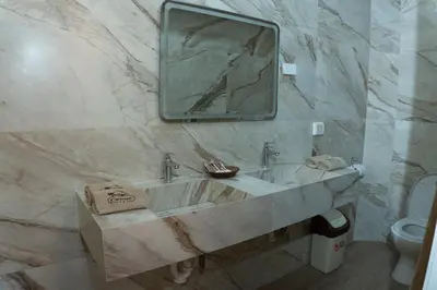 a marble bathroom with a sink and a mirror at Hotel Curasi in Ica