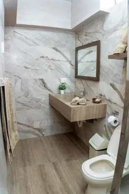 a bathroom with a toilet and a sink and a mirror at Hotel Curasi in Ica