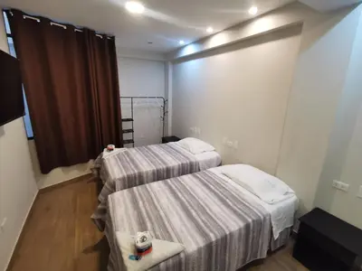 a room with two beds and a table in it at Hotel Sol de Marcona in San Juan de Marcona