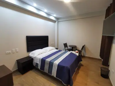 a bedroom with a bed with a blue and white blanket at Hotel Sol de Marcona in San Juan de Marcona
