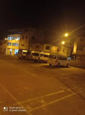 a group of buses parked in a parking lot at night at Casa Alojamiento Virreynal in San Ramón