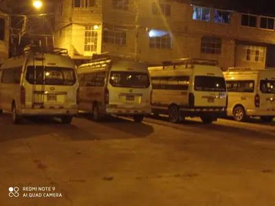 a group of buses parked on a street at night at Casa Alojamiento Virreynal in San Ramón