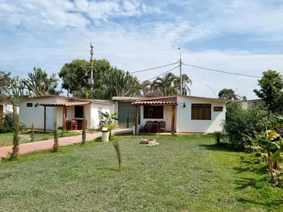 a small white house with a yard at Bungalows Payancas de Tato in Barranca