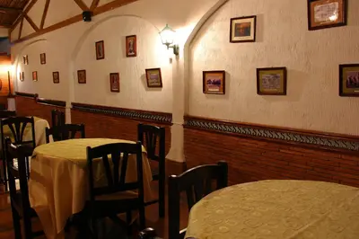 a dining room with tables and chairs and pictures on the walls at Hotel Villa de Valverde in Ica