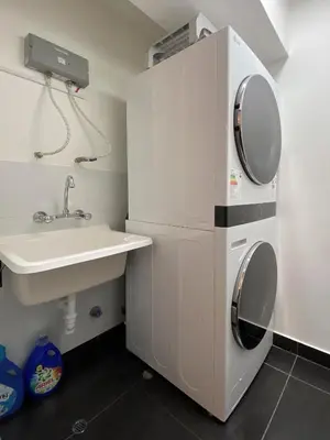 a bathroom with a sink and a washing machine at Silvia's New Spacious Patio Pad in Lima