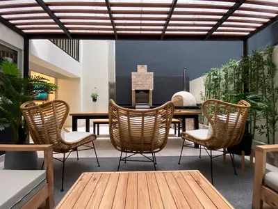 a dining room with rattan chairs and a table at Silvia's New Spacious Patio Pad in Lima