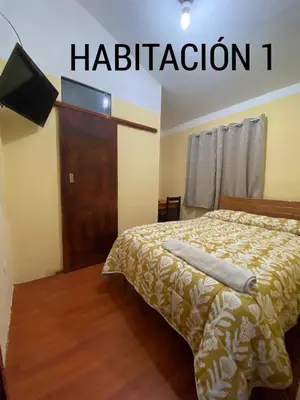 a bedroom with a bed and a flat screen tv at CASA ALVAREZ in Cusco