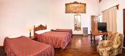 a hotel room with two beds and a television at Hotel El Huarango in Ica