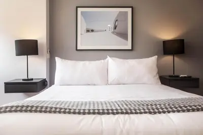 a bedroom with a white bed with two lamps at Modern Penthouse & 2BR in Miraflores by Wynwood House in Lima