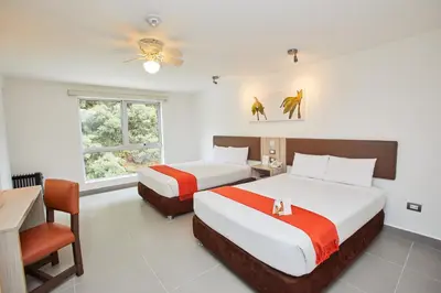 a bedroom with two beds and a table and a chair at Casa Andina Standard Machu Picchu in Machu Picchu