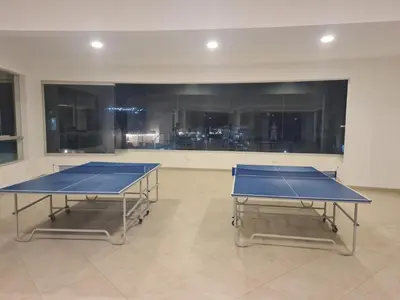two ping pong tables in a room with windows at Departamento de Playa (con piscina propia) en km 107 Asia, Lima in Asia