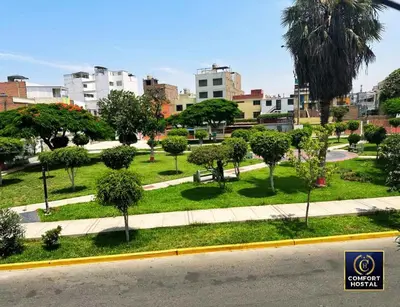 a park with trees and bushes in a city at Hospedaje Comfort Lima in Lima