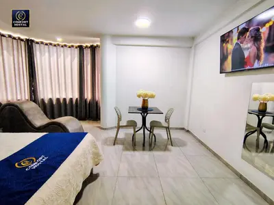 a hotel room with a bed and a table and chairs at Hospedaje Comfort Lima in Lima