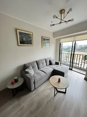 a living room with a couch and two tables at Departamento de Estreno en Barranco in Lima