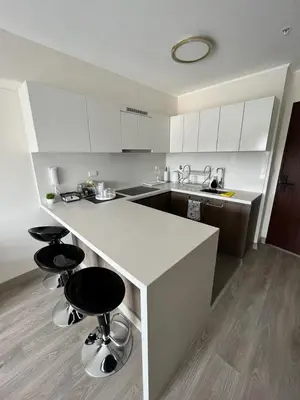 a kitchen with a counter and two bar stools at Departamento de Estreno en Barranco in Lima
