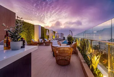 a balcony with chairs and tables on a building at Departamento de Estreno en Barranco in Lima