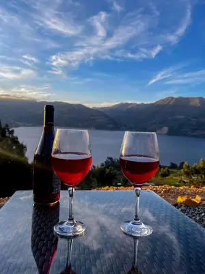two glasses of wine sitting on a table with a bottle at Pacucha Glamping in Andahuaylas