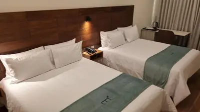 a hotel room with two beds and a telephone at Muña Hotel Andahuaylas in Andahuaylas