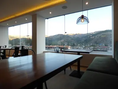 a dining room with a table and a large window at Muña Hotel Andahuaylas in Andahuaylas