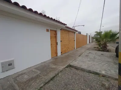 a white building with a fence and a sidewalk at Hostel Killamoon Centro in Paracas