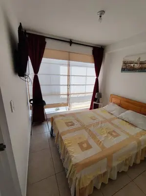 a bedroom with a large bed with a window at Excelente departamento frente al mar. in San Bartolo