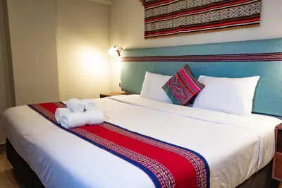 a hotel room with a large bed with two towels at Rockrivers Plaza MachuPicchu in Machu Picchu