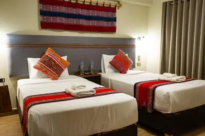 two beds in a hotel room with towels on them at Rockrivers Plaza MachuPicchu in Machu Picchu