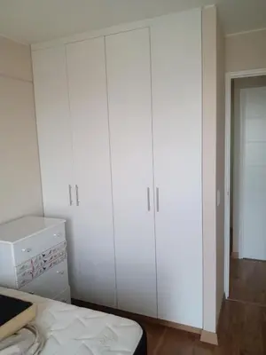 a bedroom with white cabinets and a bed at Habitación nueva para persona sola o pareja in Lima