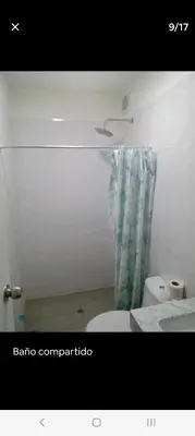 a bathroom with a toilet and a shower curtain at Habitación nueva para persona sola o pareja in Lima