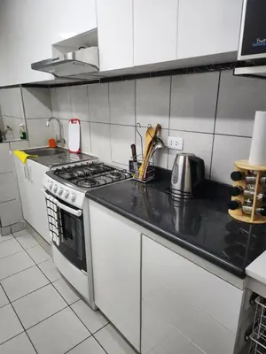 a kitchen with a stove and a counter top at Departamento amplio y acogedor San Miguel in Lima