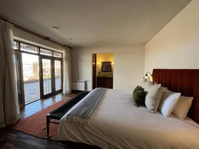 a bedroom with a large bed and a large window at Palacio Manco Capac by Ananay Hotels in Cusco