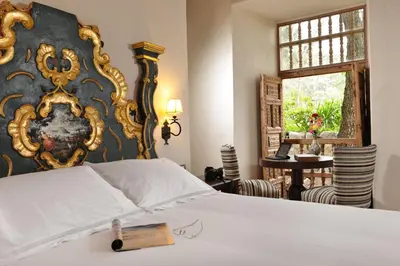 a bedroom with a bed with a gold and black wall at Palacio Manco Capac by Ananay Hotels in Cusco