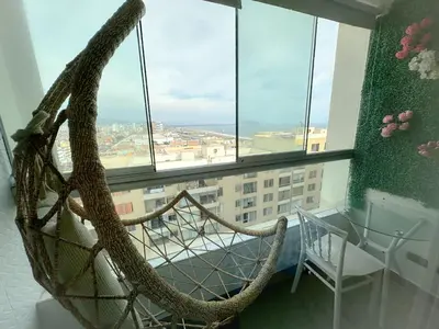 a hanging hammock in a room with a window at Departamento con vista al mar y piscina - Pool One in Lima